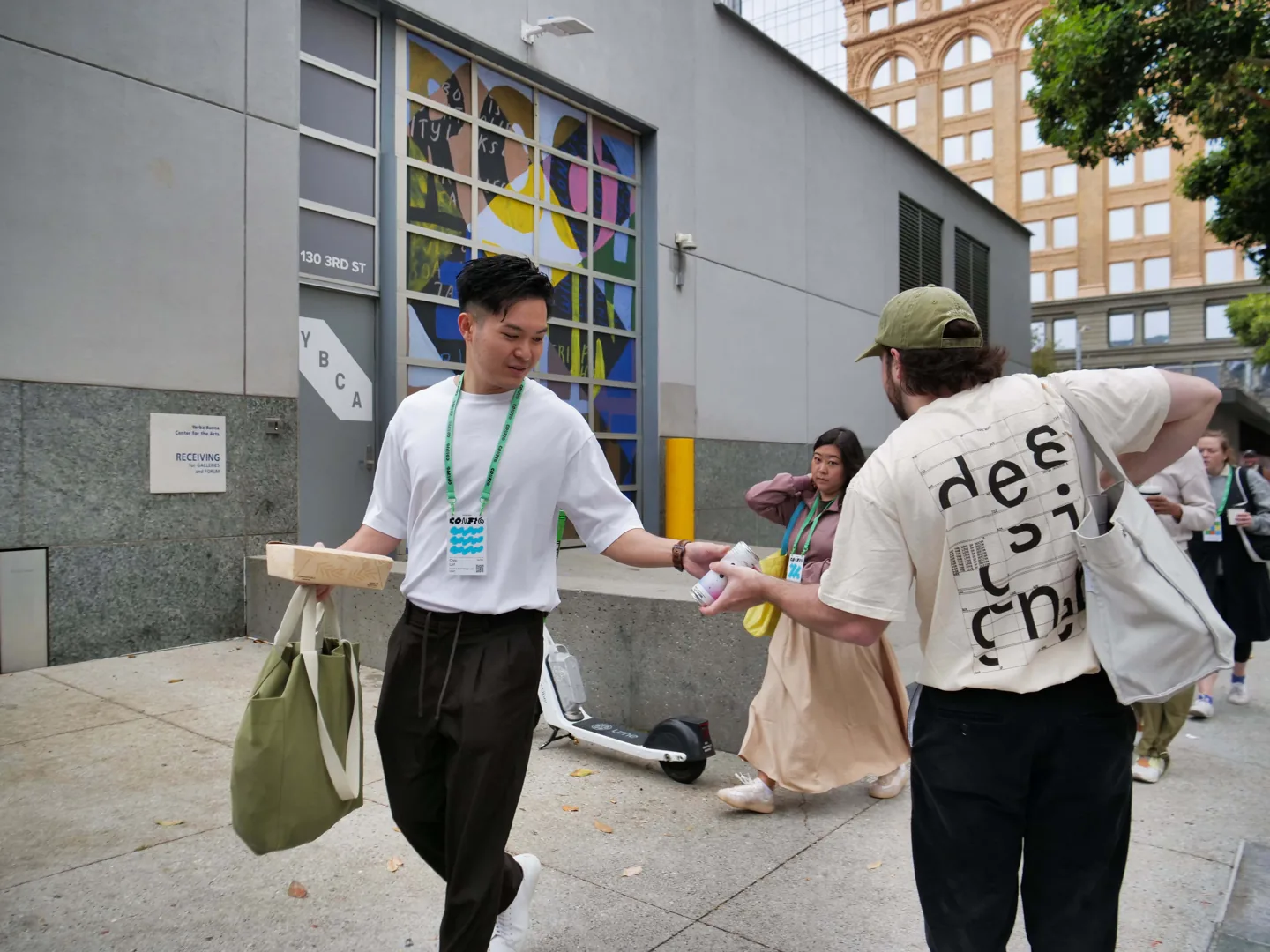 A man walking on the sidewalk with a Paper can
