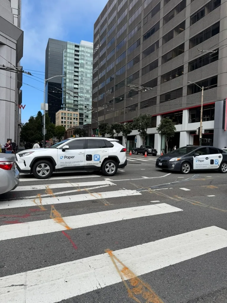 Paper LED trucks crossing an intersection near Moscone