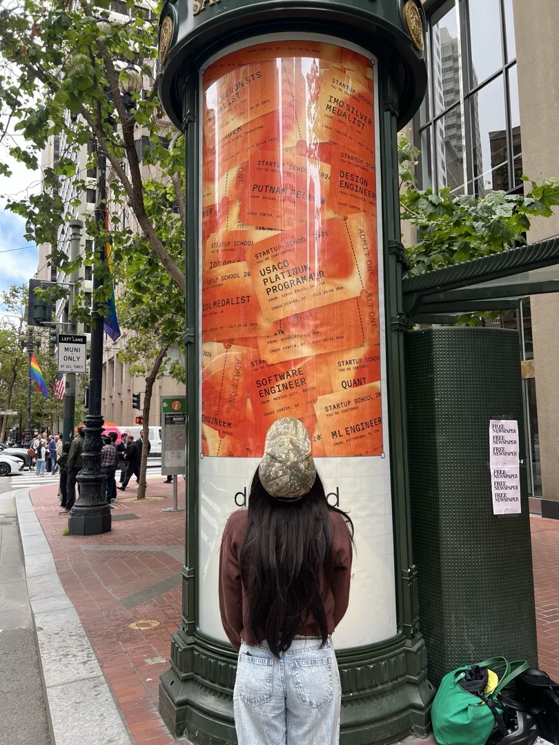 A person beside a Paper newsstand advertisement