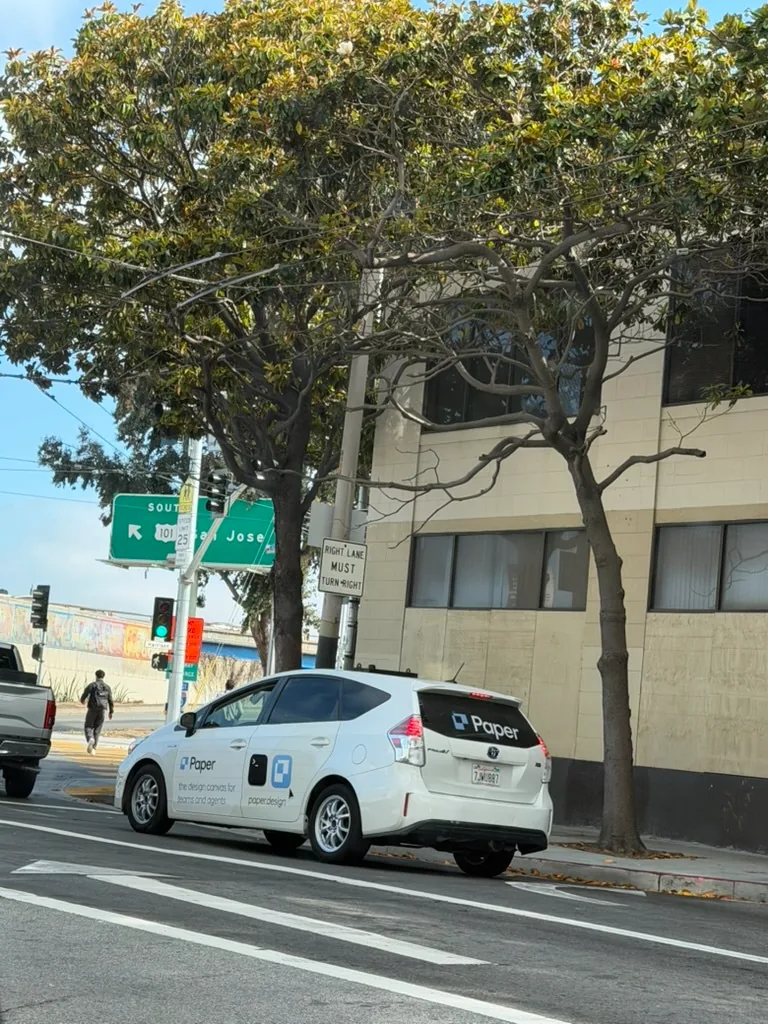 A white car with Paper branding in SF traffic
